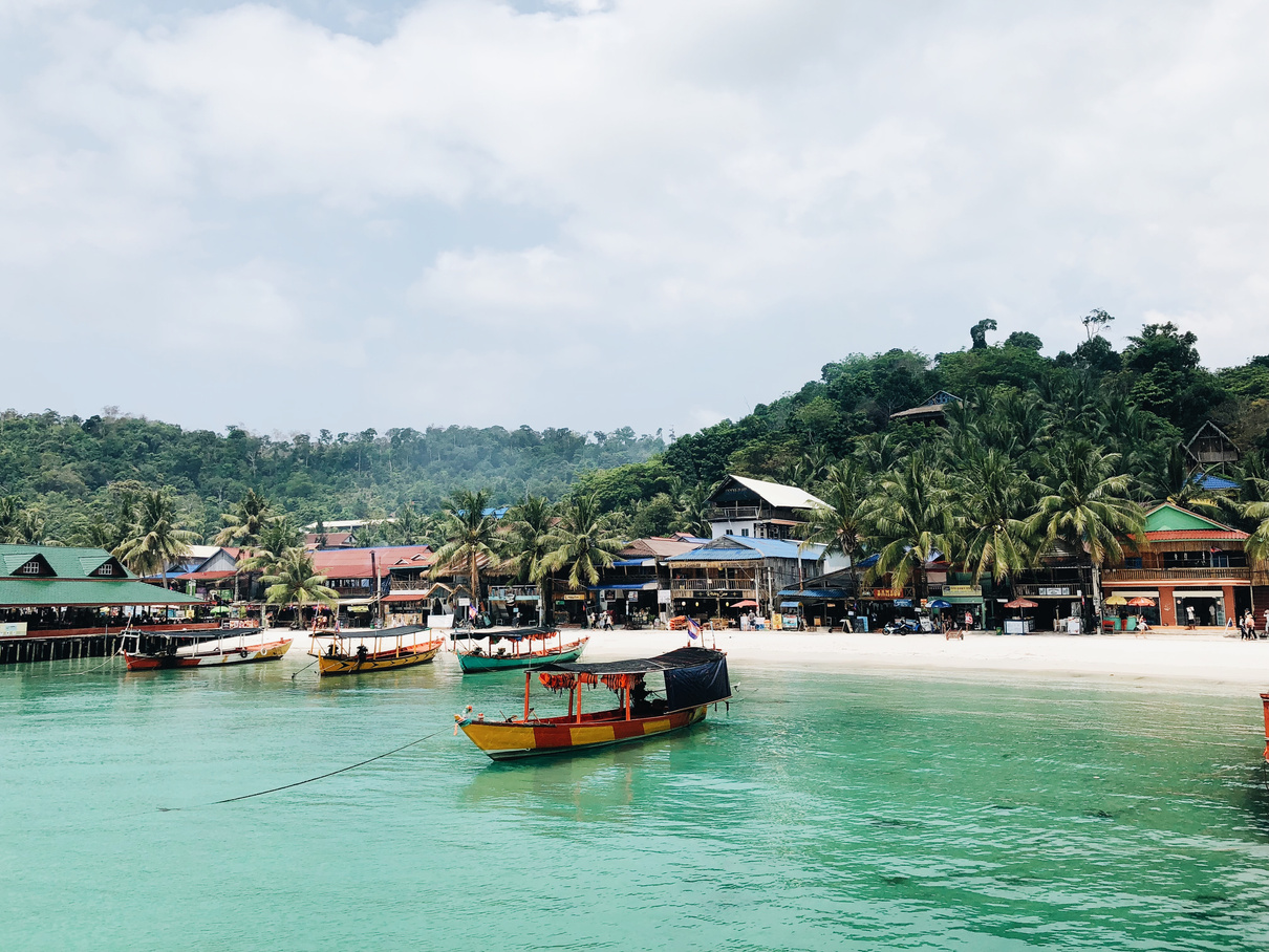 Yellow and Red Boat With Roof Near White Sanded Beach on a Tropical Island